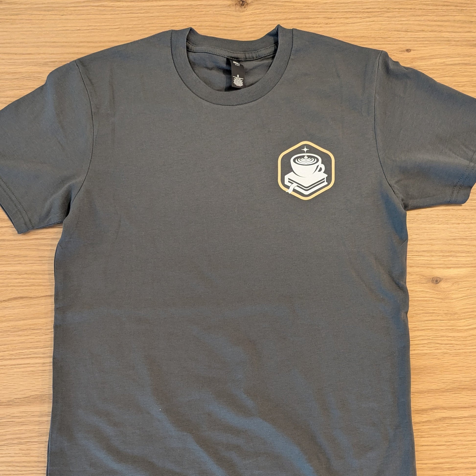 Gray t-shirt with a logo on a wooden surface